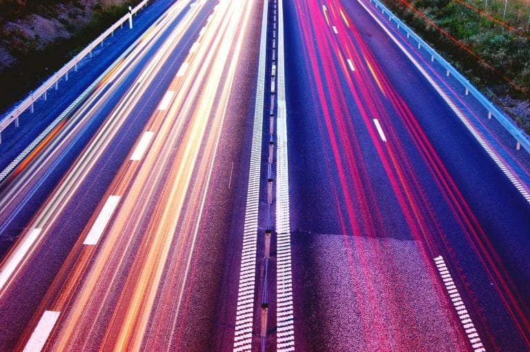 Das Bild zeigt eine Autobahn, die Lichter sind verschwommen. Keine Autos sind zu sehen, Schnelligkeit soll dargestellt werden.