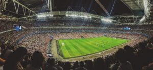 Shows a full soccer stadium in floodlight illumination