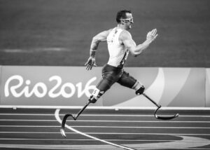 Uomo con protesi alle gambe che corre in pista