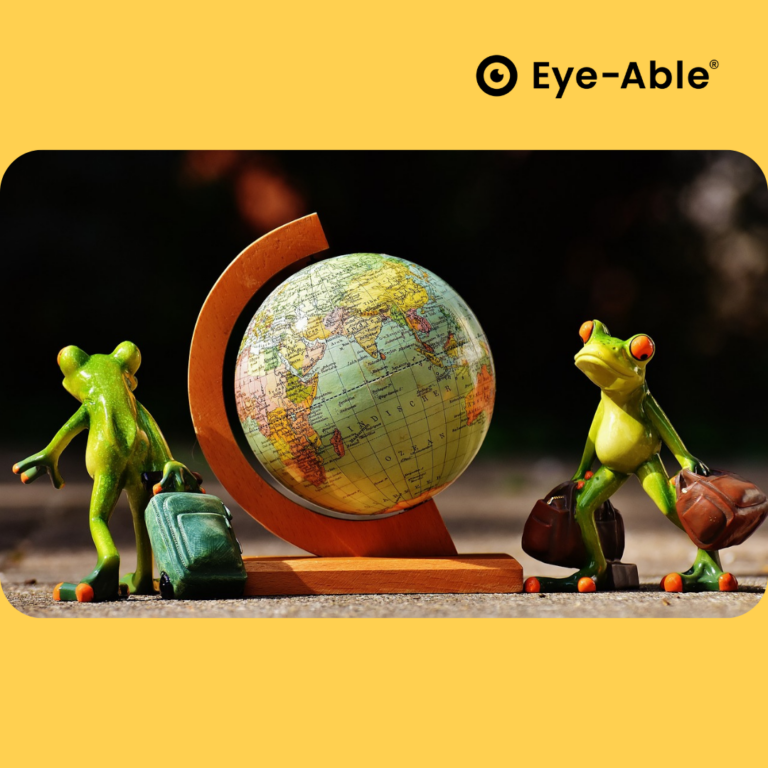 Two frogs stand upright with suitcases in front of a globe.
